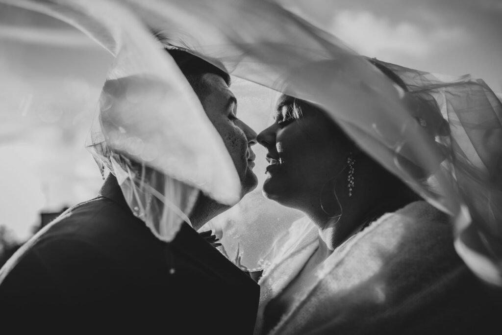 sesja ślubna fotograf ślubny, wesele nad morzem, para młoda, welon, zdjęcie czarno białe