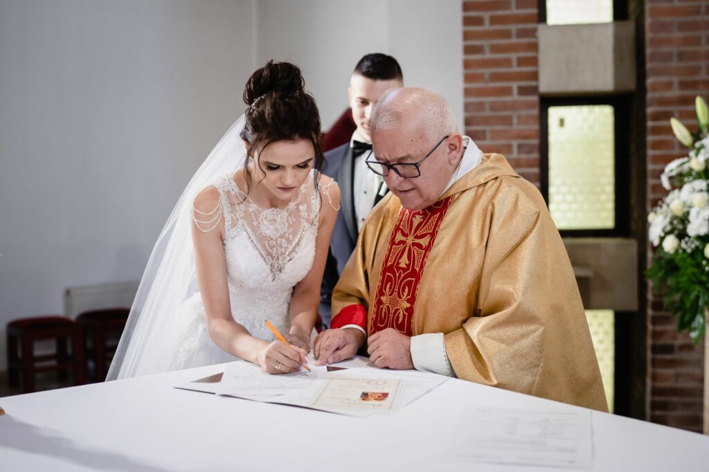 ślub w Koszalinie, Barbara Rompska, fotograf Koszalin, podpisanie dokumentów, panna młoda, ksiądz