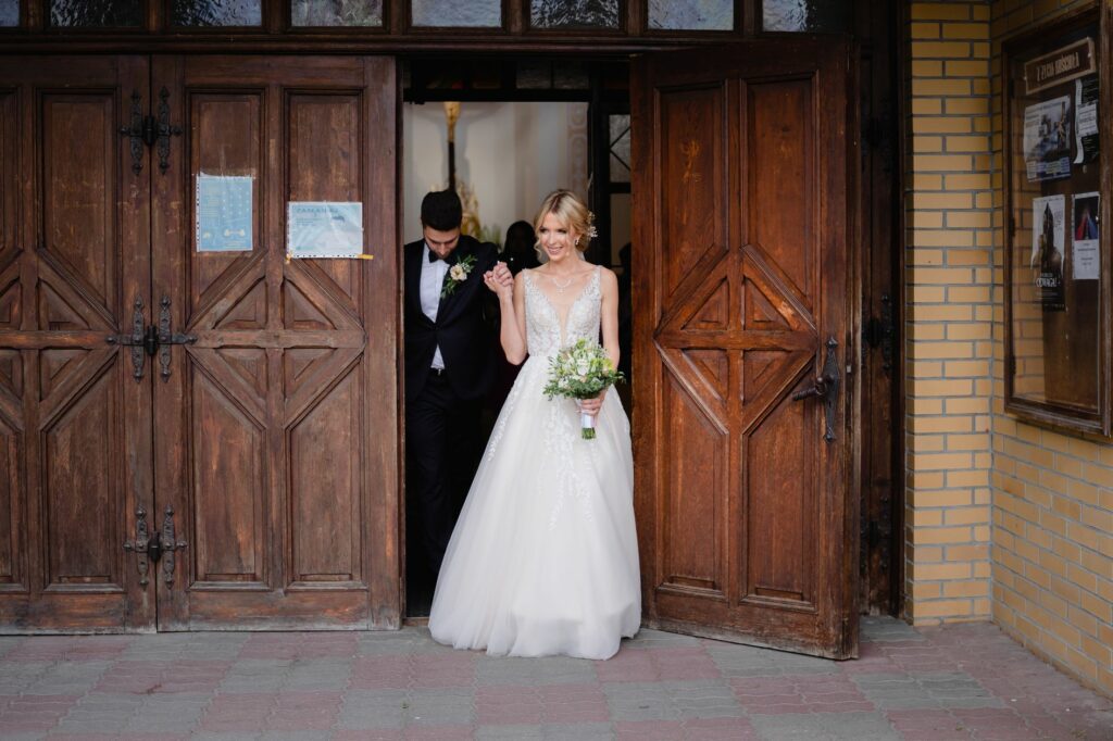ślub kościelny, fotograf Koszalin, Barbara Rompska, nowożeńcy, wyjście z kościoła