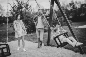 plenerowa sesja rodzinna, Koszalin, Barbara Rompska, plac zabaw, huśtawki, zdjęcie czarno białe
