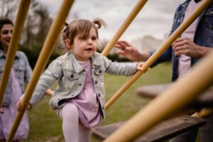 plenerowa sesja rodzinna, plac zabaw, rodzice, dziewczynka, sukienka w grochy, jeansowa kurtka,Koszalin, Barbara Rompska,