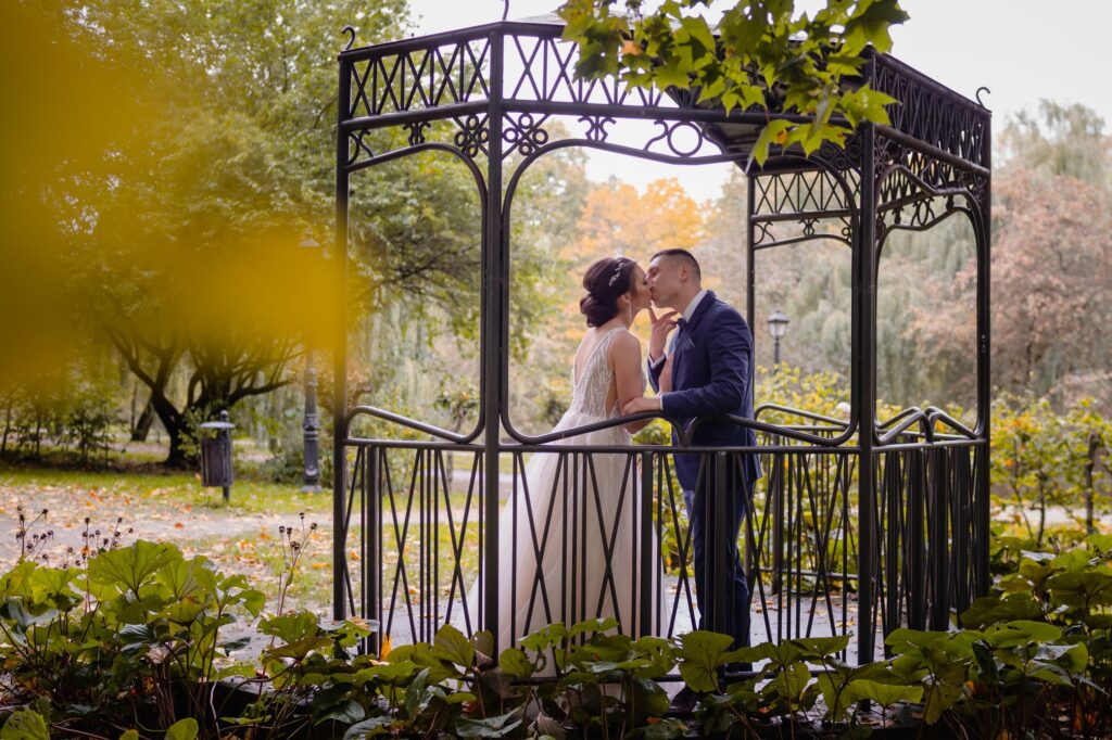 sesja ślubna w Koszalinie, Barbara Rompska, fotograf na wesele, nowożeńcy, altanka, park, pocałunek