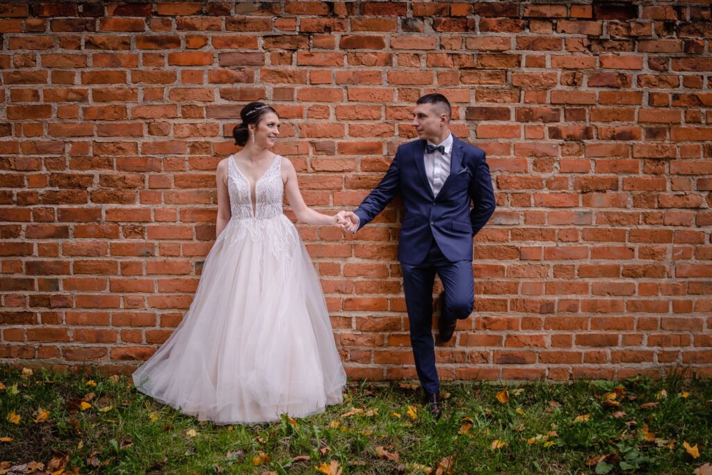 sesja ślubna w Koszalinie, Barbara Rompska, fotograf na wesele, nowożeńcy, zdjęcia w plenerze, suknia ślubna, czerwony mur