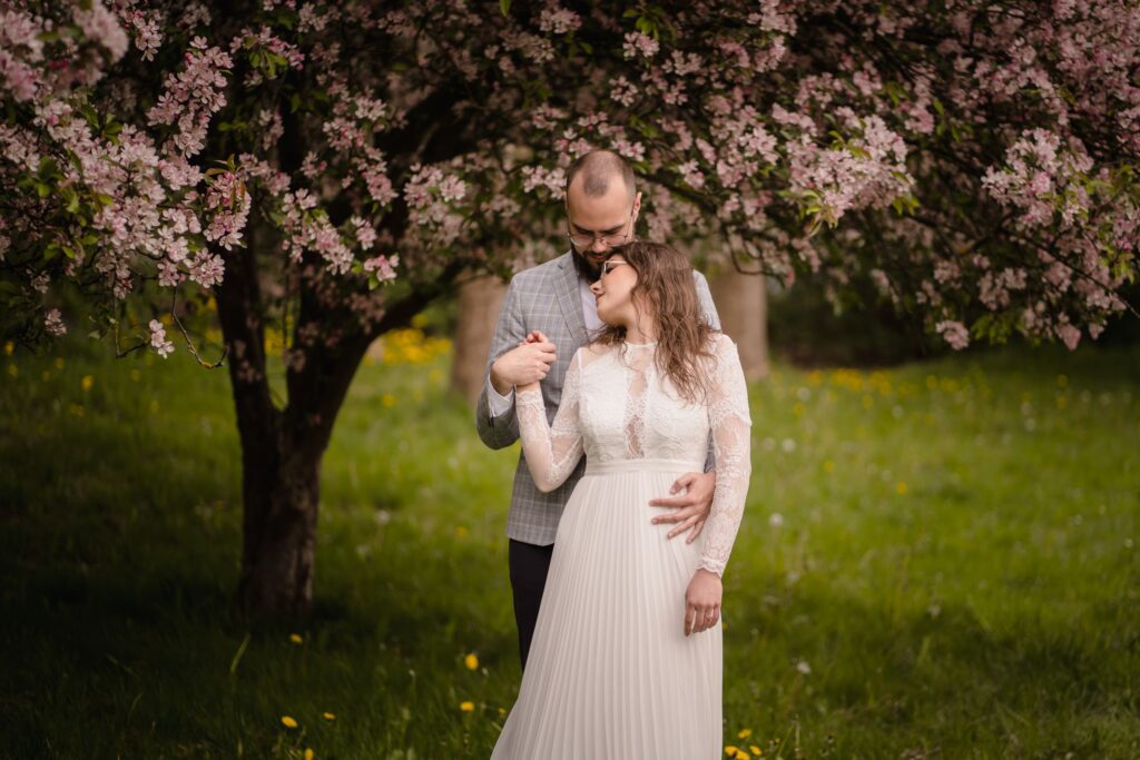 sesja ślubna, plener, kwitnące krzewy Barbara Rompska, fotograf Koszalin, park, para młoda
