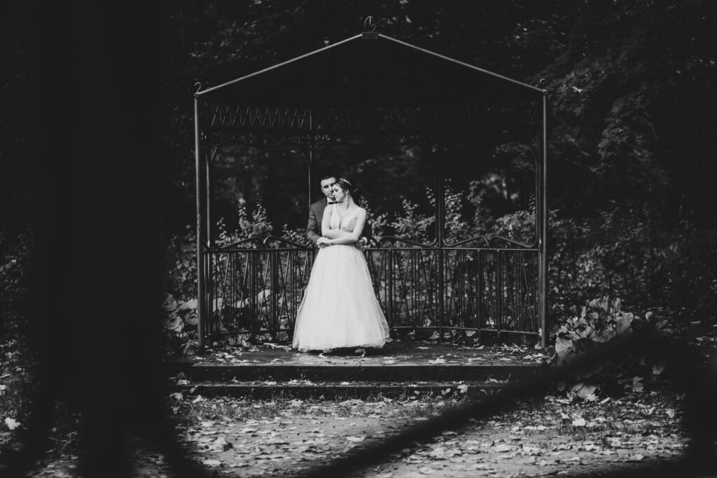 sesja ślubna w Koszalinie, Barbara Rompska, fotograf na wesele, nowożeńcy, altanka, park, czarno białe zdjęcie