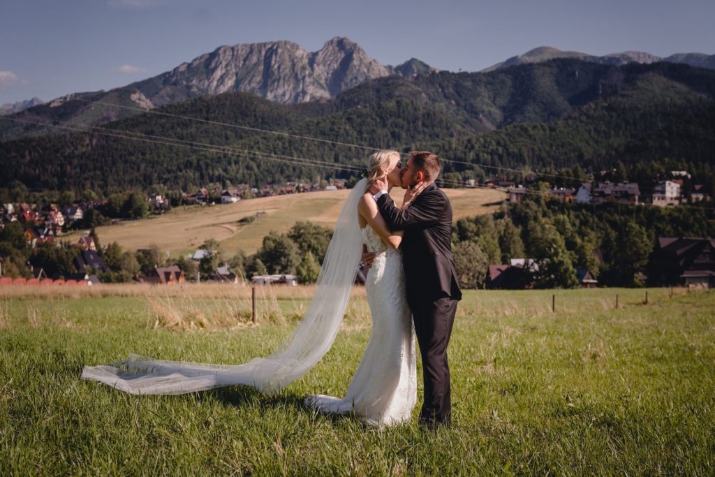 sesja ślubna w górach, Zakopane, Tatry, Rompska Fotografia, fotograf na wesele, para młoda, widok na Giewont, długi welon